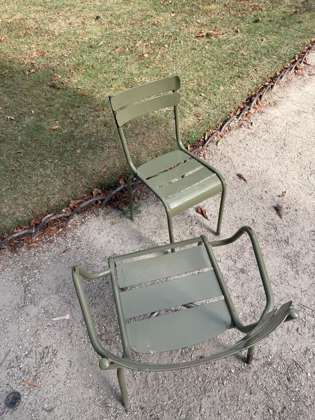 Two chairs on the gravel, one upright and one tipped back, facing each other.